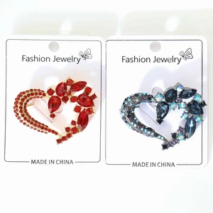 Detail of red and blue rhinestone heart brooches with gold and gunmetal alloy settings