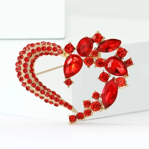 Detailed view of heart brooch with red rhinestones and gold alloy floral accents