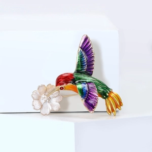 Broche colibri colorée et fleur avec émail vibrant sur un support géométrique
