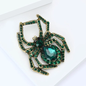 Detailaufnahme der Vintage Spinne Brosche mit grünen Kristallen und Strass