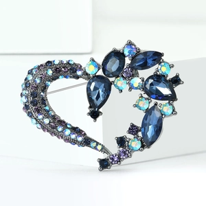 Macro shot of heart-shaped brooch with deep blue crystals and gun-black alloy finish