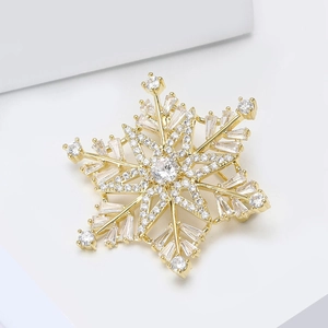 Elegant gold snowflake brooch with sparkling cubic zirconia stones for women's suits