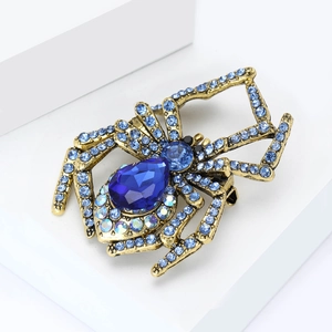 Detailed macro view of vintage spider brooch with blue crystals on a golden base