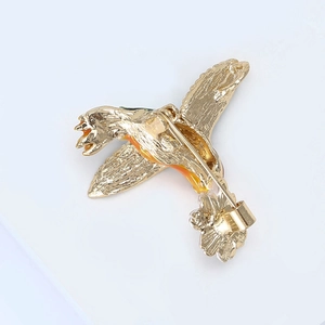Vue détaillée du dos de la broche colibri montrant le fini métal doré et le fermoir épingle