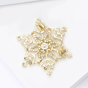 Exquisite golden snowflake brooch with zircon stone and intricate hollow metal patterns