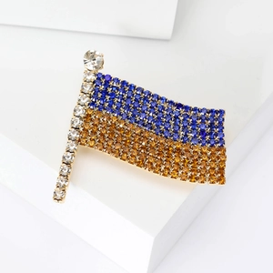 Elegant Ukraine flag brooch with blue and gold rhinestones on a minimalist white stand