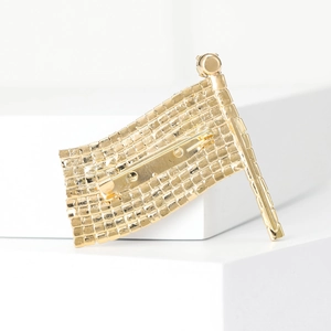 Detailed back view of a gold flag brooch with a secure metal pin fastening mechanism