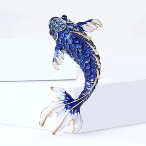 Detail of red koi fish brooch with blue enamel scales and sparkling crystal accents