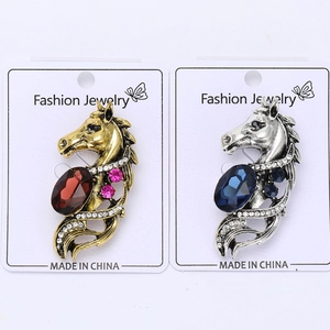 Detail of horse-head brooches with rhinestones in gold and silver finish options
