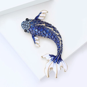 Macro shot of koi fish brooch with blue enamel scales, rhinestones and golden details