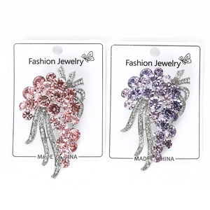 Detailed view of rhinestone flower brooches in pink and purple colors on jewelry card