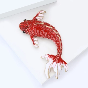 Macro shot of koi fish brooch featuring red enamel scales and sparkling crystal details