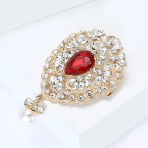 Detail der Vintage-Brosche mit rotem Tropfenstein und baumelndem weißen Perlenanhänger