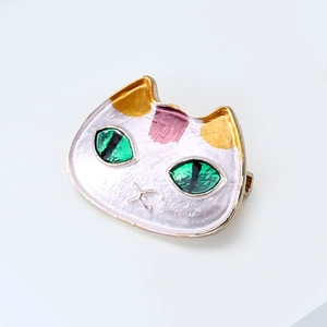 Detailansicht der niedlichen Katzen-Emaille-Brosche mit grünen Augen und Goldpunkten