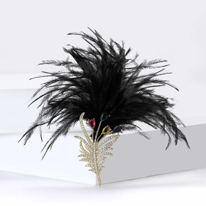 Elegant gold-plated feather brooch with zircon stones and black feathers on white stand