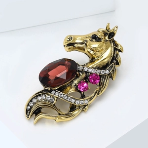 Macro detail of vintage horse head brooch with red gemstone and sparkling crystals