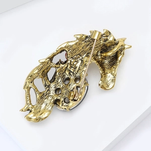 Detailed back view of vintage gold horse brooch showing safety pin clasp and metal texture