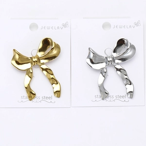 Détails de broches en forme de nœud polies or et argent sur carte de bijoux
