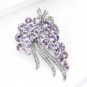 Detailed close-up of a silver flower brooch with purple crystals and small diamonds
