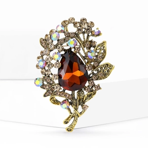 Detail shot of vintage flower brooch with amber crystal and AB diamonds on antique gold