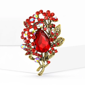 Macro detail of vintage flower brooch with large red teardrop crystal and AB rhinestones