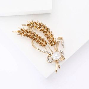 Detail of wheat ear brooch with amber rhinestones, white pearl, and gold alloy finish