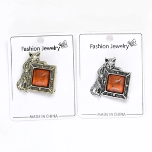 Détails macro de broches chat avec pierres orange en finitions or antique et argent