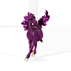 Detailed macro shot of a purple crystal Pegasus brooch with gold accents on white stand