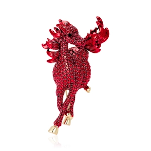 Detailed macro view of vibrant red rhinestones on the golden winged horse brooch pin