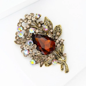Macro shot of vintage gold floral brooch with large brown teardrop crystal and rhinestones