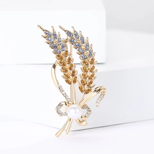 Detail of elegant gold wheat brooch with blue crystals and a pearl ribbon bow