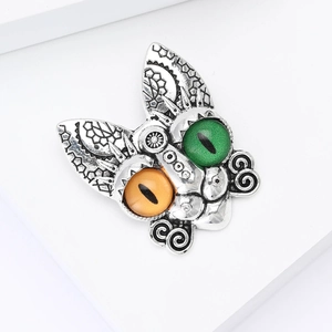 Detailed close-up of retro silver cat brooch featuring unique bicolor green and orange eyes