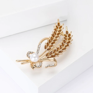 Macro detail of elegant wheat ear brooch with amber rhinestones and white pearl