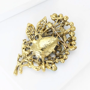 Macro back view of vintage gold crystal brooch showing detailed hollow design and metal pin