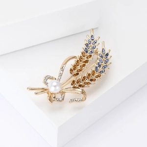 Detailed macro view of an elegant wheat stalk brooch with rhinestones and a white pearl