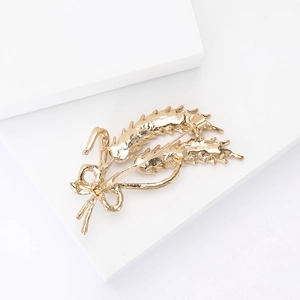 Detail view of the back pin mechanism on the golden wheat ear brooch with bow tie
