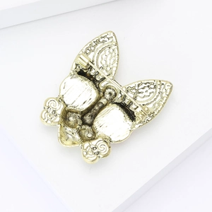 Detail view of the golden alloy dog brooch back with safety pin clasp and textured finish