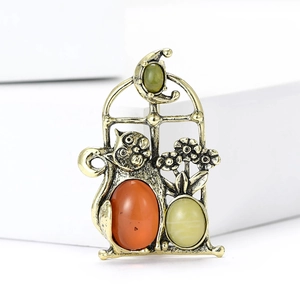 Detailed close-up of retro cat window brooch with antique gold finish and gemstones