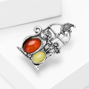 Detailed close-up of retro silver cat brooch with amber stones and floral accents