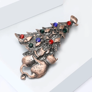 Close-up of vintage bronze Christmas tree brooch with cats and colorful rhinestones