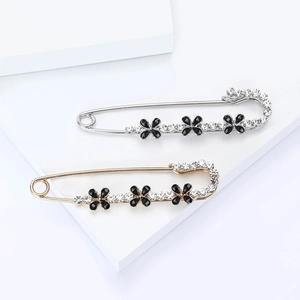 Broches trèfle à quatre feuilles élégantes en or et argent avec strass sur fond blanc