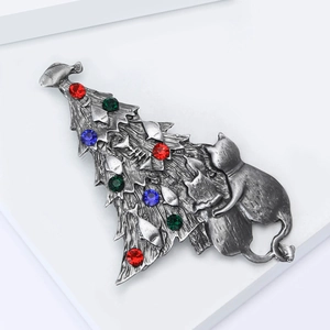 Detailed macro view of vintage silver cat and Christmas tree brooch with colorful rhinestones