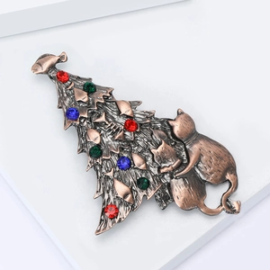 Detailed close-up of a vintage bronze Christmas tree brooch with colorful rhinestones and cats
