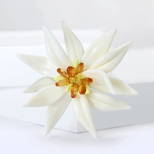 Élégante broche fleur d'edelweiss blanche avec cristaux ambrés sur fond minimaliste