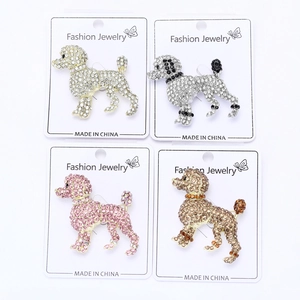 Gros plan de broches caniche en quatre couleurs avec strass étincelants sur cartes