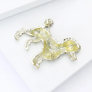 Vue arrière détaillée d'une broche chien dorée montrant le fermoir et la texture du métal