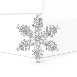 Eleganter silberner Schneeflocken-Anstecker mit funkelnden Kristallen auf weißem Grund