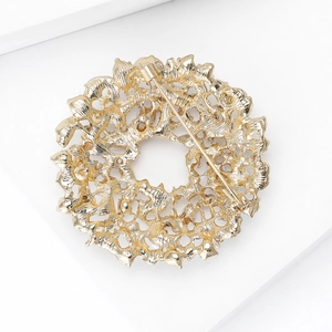 Macro shot of gold sunburst brooch back with secure pin clasp on white display