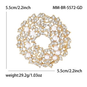 Detailed view of alloy flower brooch with rhinestones and pearls on a gold base
