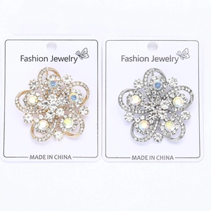 Detailed macro view of gold and silver flower brooches with sparkling crystal rhinestones